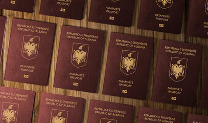 Passports of Albanian , top view, on a wooden table ,The Albanian passport is a travel document issued by the Ministry of Interior to Albanian citizens to enable them to travel abroad