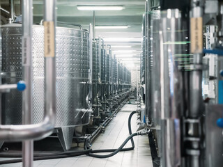 Steel vats, containers or barrels for fermenting wine in factory.