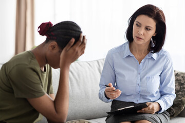 Professional Psychologist Lady Having Therapy Session With Depressed Black Female Soldier