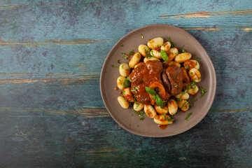 Ossobuco served with gnocchi.