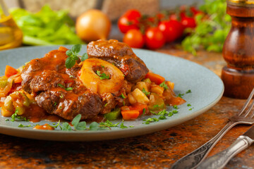 Ossobuco served with stewed vegetables.