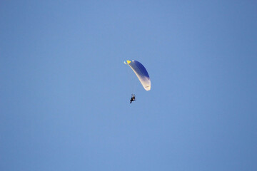 Parachutist on a blue sky background.