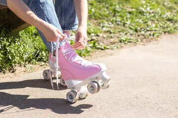 Obraz premium legs of a woman tying pink roller skates