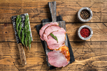Cold Smoked pork sirloin meat with herbs on rustic board. Wooden background. Top view