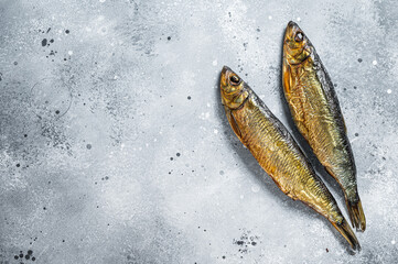 Hot smoked whole herrings on kitchen table. Gray background. Top view. Copy space