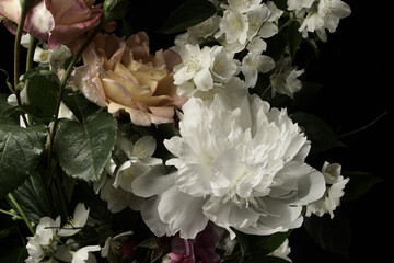 White peonies and roses on a black background, close-up, studio shot.