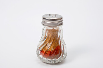 Glass container with a metal screw-on lid with holes for ground pepper.