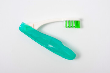 Folding plastic toothbrush for travel and tourism, shot on a white background.