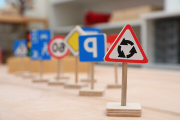 Different miniature road signs on wooden table, space for text. Montessori toy