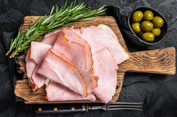 Pork ham slices on cutting board, Italian Prosciutto cotto. Black background. Top view