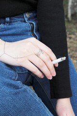 a lit cigarette in the girl's hand