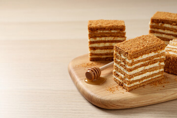 Delicious layered honey cake on wooden table. Space for text