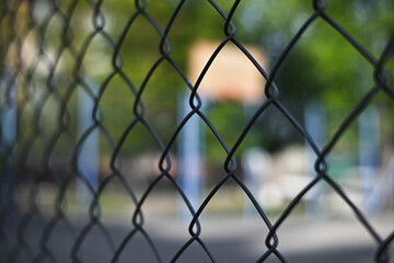 Fototapeta premium chain link fence against a basketball court