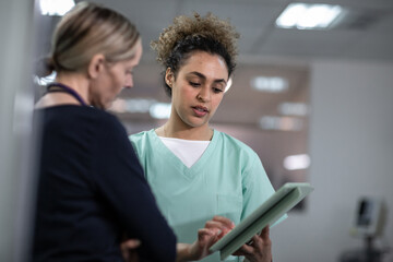 Female surgeon discussing patient treatment using a digital tablet to review x-ray