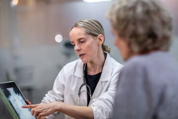 Female Medical Doctor looking at x-ray results on a digital tablet