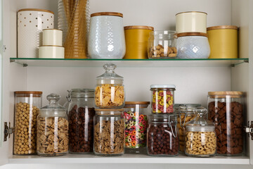 Glass containers with different breakfast cereals and other products on shelves