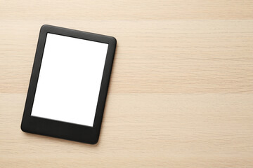 Modern e-book reader with blank screen on wooden table, top view. Space for text