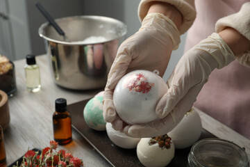 Woman in gloves with self made bath bomb at table, closeup