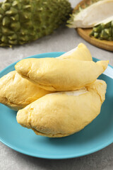 Plate with fresh ripe durian on grey table, closeup