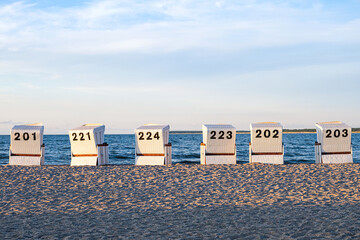 Six beach chairs on the sandy beach at the baltic sea.