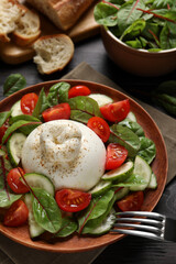 Delicious burrata salad served on wooden table, above view