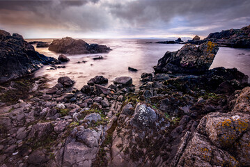 Rocky seascape beside Turnberry point lighthouse with cloudy moody sky  at coast line