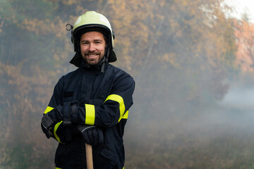 Portrait of happy firefighter man looking at camera after successful action in forest