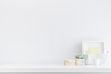 Home office desk with office supplies and empty table space. White, minimal workspace. Mockup.