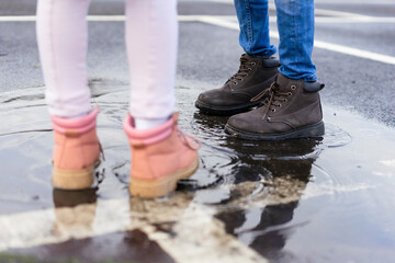 Girl and boy standing in puddle
