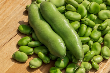 Both broad bean pods and shelled seeds. Healthy organic green raw broad beans.