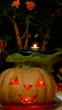 Home decoration with spooky glows halloween pumpkin head Jack Lantern face and burning candle.