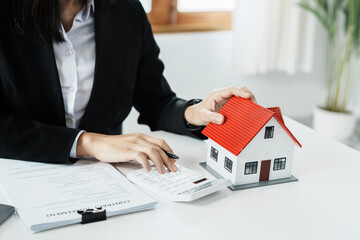Entrepreneurs, business owners, accountants, real estate agents, A young woman uses a calculator to calculate her home budget to assess the risks of investing in real estate.