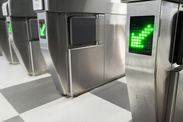 Entrance gate with green arrow direction sign in metro subway station