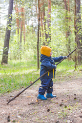 Toddler boy walks in the forest
