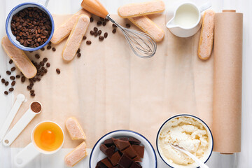 Tiramisu dessert. Ingredients for making dessert tiramisu. Cooking Italian food dessert Tiramisu with all necessary ingredients cocoa, coffee, mascarpone cheese on white stone background. Mock up.