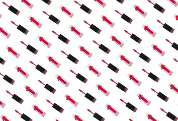 Creative pattern made of red liquid lipstick or lip gloss. Set of decorative cosmetics on white background. Make up and fashion concept. Top view. Flat lay.