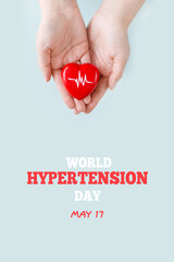 World Hypertension Day. Women's hands hold red heart with heartbeat chart - a symbol of high blood pressure. Hypertension Day in May 17th. World heart day, world health day.