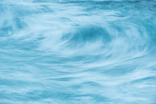 Turquoise ocean waves as backdrop. Sea water boils and foams during surf. Mountain blue river with fast current