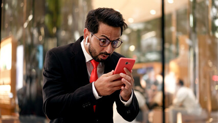 Young Businessman happy with Good News on Mobile phone