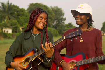 Two young women playing guitars