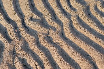 Wavy sand surface. Natural abstract texture. Solar side light and unique shadow pattern.