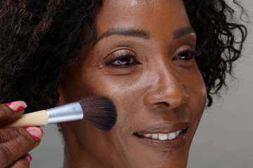 Obraz premium Studio shot of mature woman applying make-up