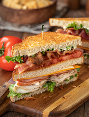 Club sandwich made with bacon ham turkey cheese lettuce and tomato