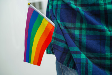 Asian woman with rainbow flag, LGBT symbol rights and gender equality, LGBT Pride Month in June, LGBTQ, LGBTI, LGBTQA, LGBTQIA