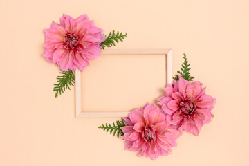 Flower frame made of dahlia on a pink background. Festive composition with copyspace.