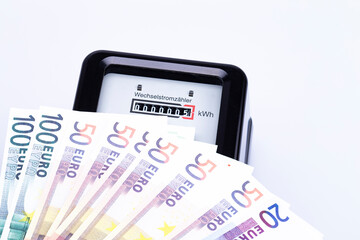 The photo shows an AC electricity counter with euro bills 