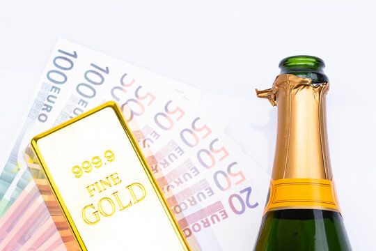 The Photo Shows The Top Of A Champagne Bottle Isolated On White Background With Banknotes And A Gold Brick