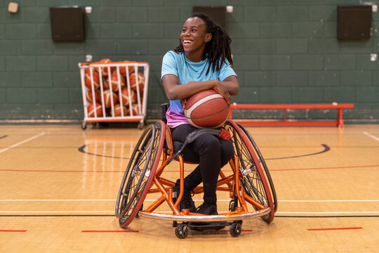 Teenage girl in wheelchair on basketball court