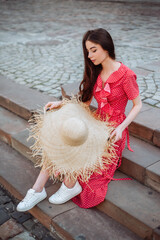 Pretty girl wearing red polka dot dress and white sneakers