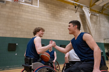 Fototapeta na wymiar Men in wheelchairs shaking hands after match